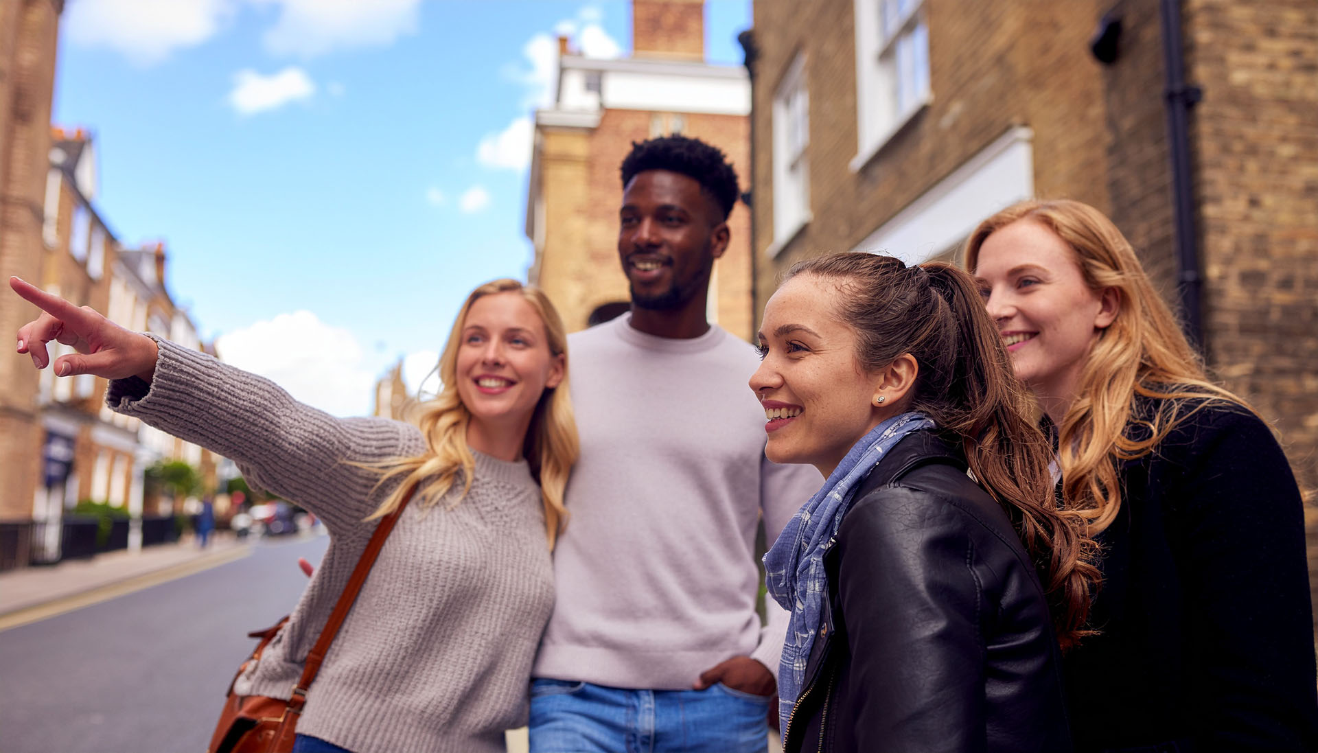 Three people smiling in a city street, representing Urban Trails affiliate partners.